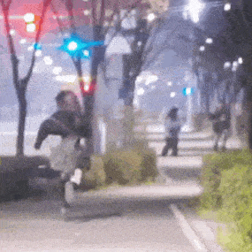 a blurry picture of a person riding a horse down a street at night .