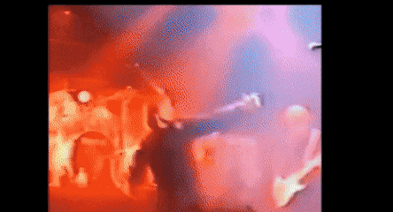 a blurry picture of a man playing a guitar in front of a crowd