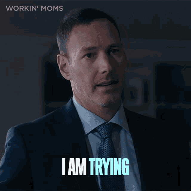 a man in a suit and tie says i am trying in blue