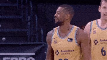 two basketball players are standing next to each other on a court .