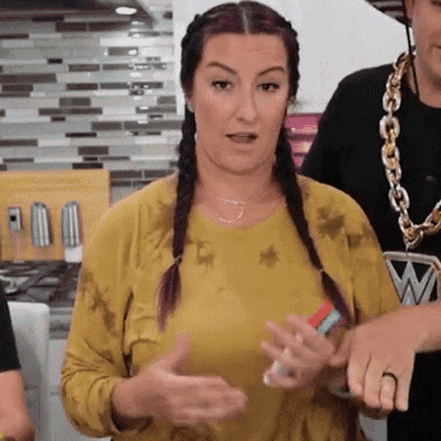 a woman in a yellow shirt with braids is talking
