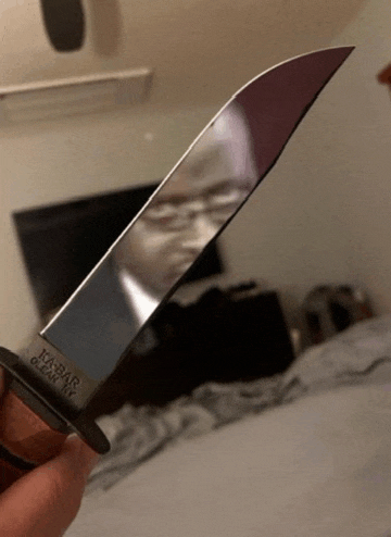 a person is holding a knife that says ka-bar on the blade