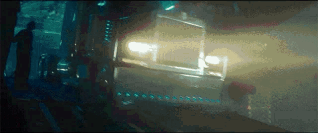a car is driving down a dark street in a futuristic city