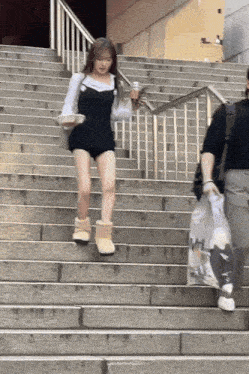 a woman is walking up a set of stairs while holding a cup