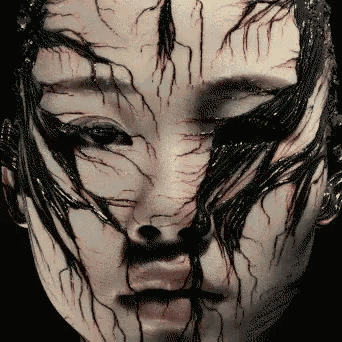 a close up of a woman 's face with black and white paint covering it