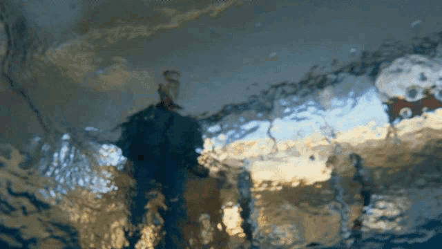 a blurry picture of a person standing in a pool of water