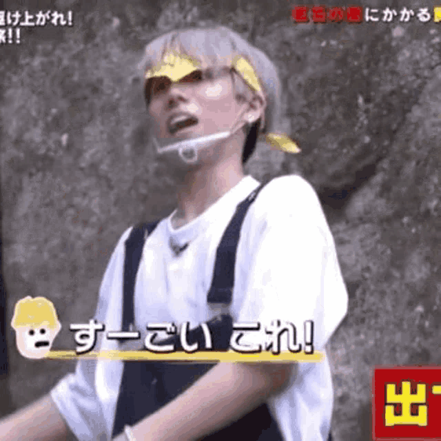 a man wearing overalls and a bandana on his head is talking in a video .