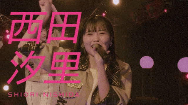 a girl singing into a microphone with the name shiori nishida written in pink