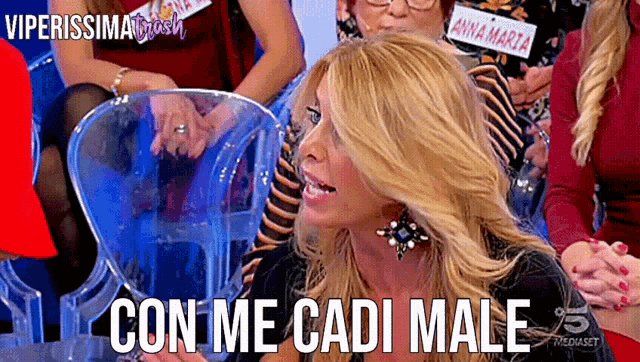 a woman sitting in a chair with the words con me cadi male written on her face