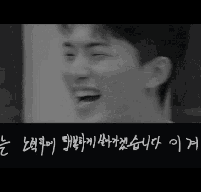 a black and white photo of a man laughing with chinese writing below him