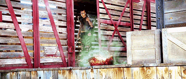 a man is standing in a wooden building with a smoke coming out of it