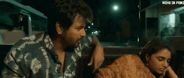 a man and a woman are sitting in a car at night .