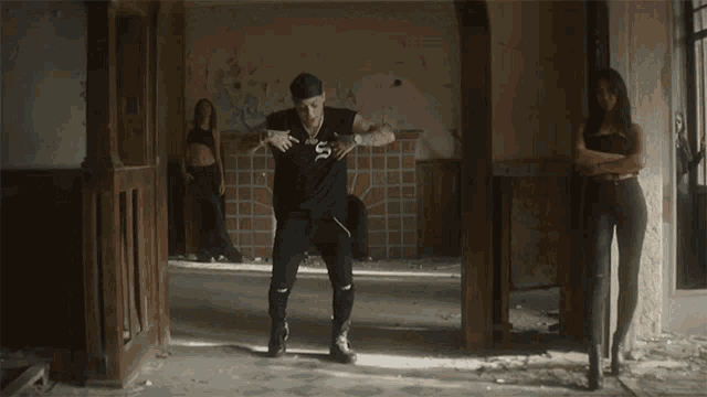 a man wearing a black shirt with the letter s on it is dancing