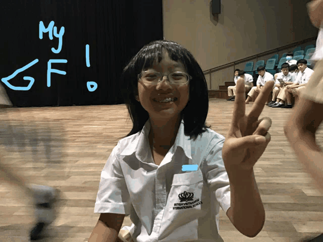 a girl giving a peace sign in front of a sign that says my gf on it