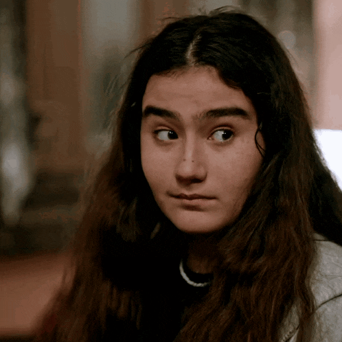 a girl with long hair looks at the camera