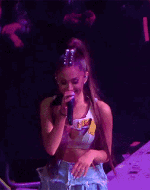 a woman is singing into a microphone on stage