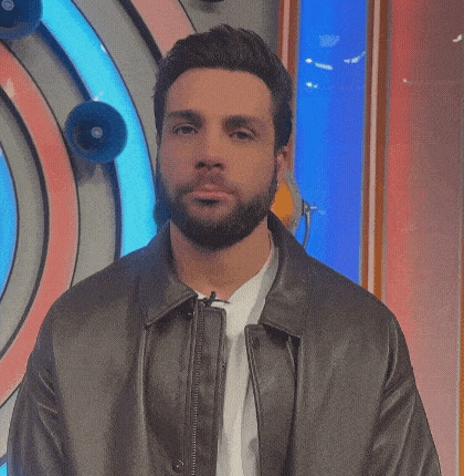 a man with a beard wearing a leather jacket and a white shirt