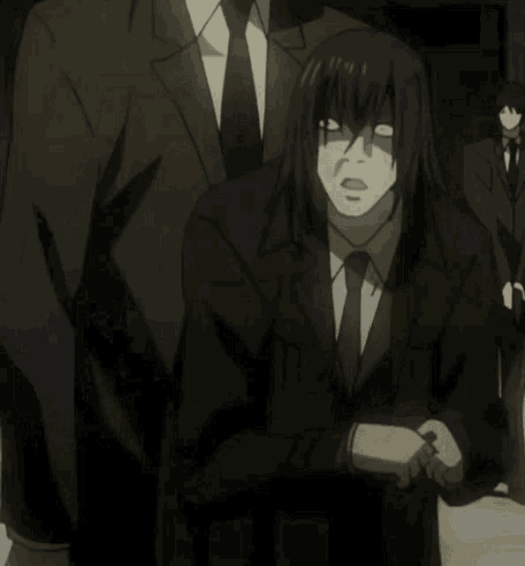 a man in a suit and tie stands in front of two other men