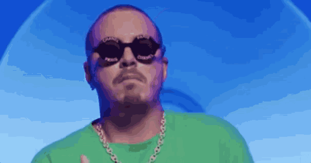 the man is wearing sunglasses and a green shirt .