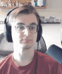 a young man wearing glasses and headphones looks at the camera .