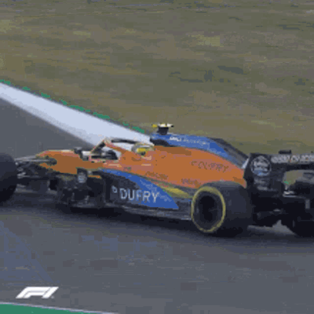 a race car is driving down a track with a sign that says f1 on it