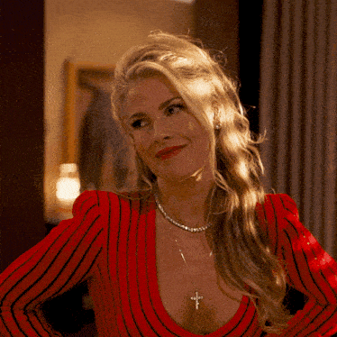 a woman wearing a red striped top and a necklace with a cross on it