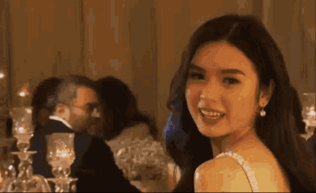 a woman in a white dress is smiling at the camera