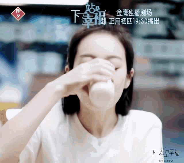 a woman drinking from a bottle with chinese writing on the bottom