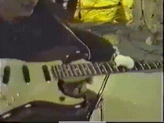 a man is playing a guitar in a blurry photo