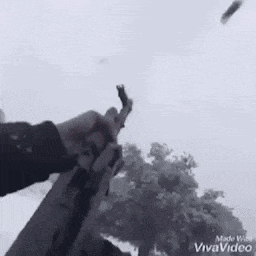 a man is holding a gun in the snow .