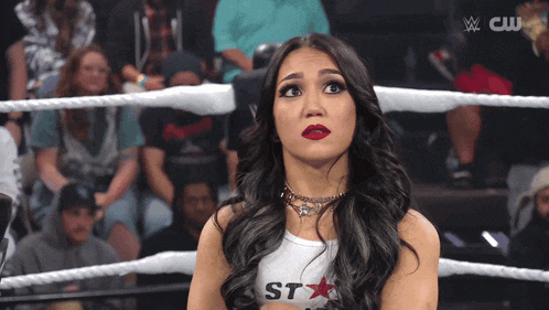 a woman in a wrestling ring wearing a shirt that says st