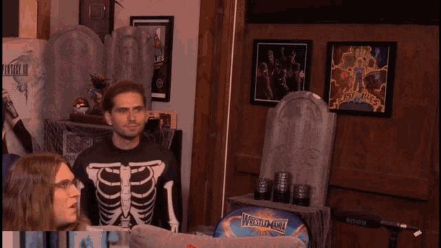 a man in a skeleton shirt is talking to a man in a blue costume