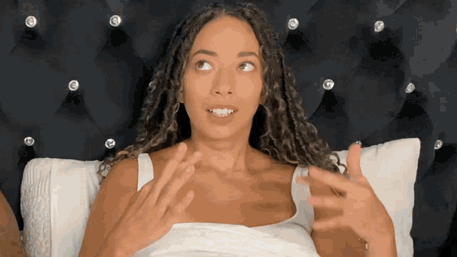 a woman is laying on a bed with a black headboard