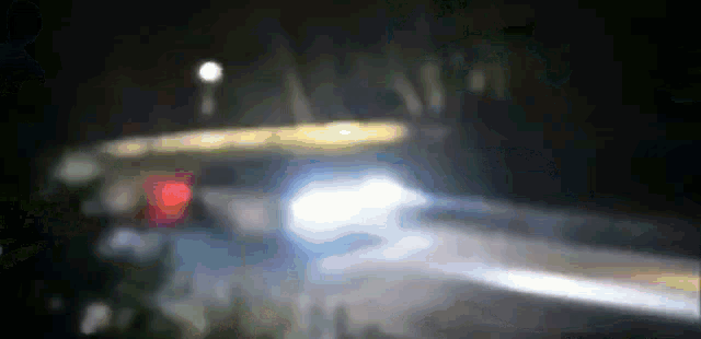 a blurred image of a car driving down a road at night