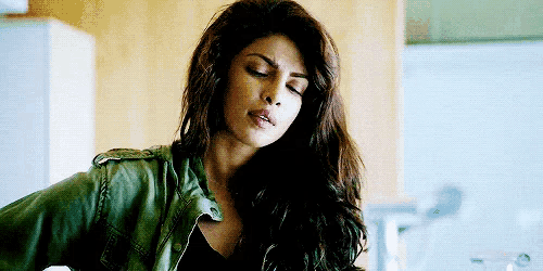 a woman with long hair is wearing a green jacket and a black top .