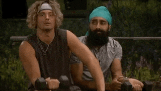a man with a beard is sitting next to another man holding dumbbells .