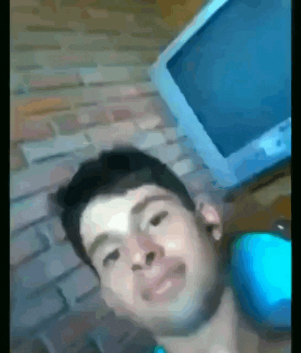 a blurry picture of a man sitting in front of a tv