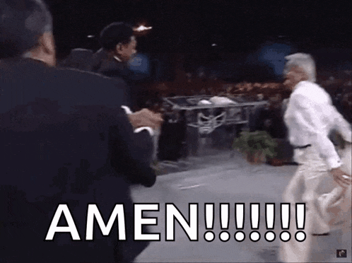 a man in a suit says amen while another man looks on