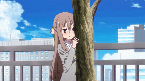 a girl in a suit is hiding behind a tree and making a face