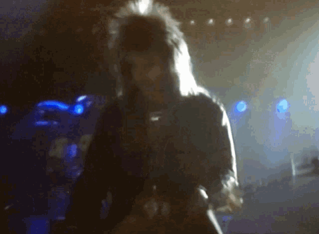 a blurred image of a person playing a guitar on a stage