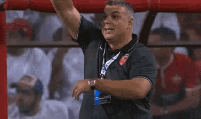 a man in a black shirt with a lanyard around his neck that says ' uefa '