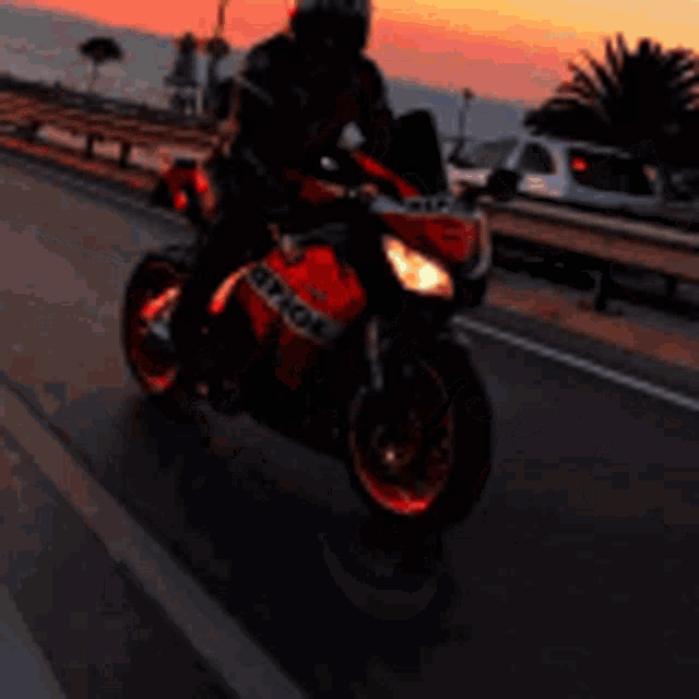 a man is riding a red and black repsol motorcycle