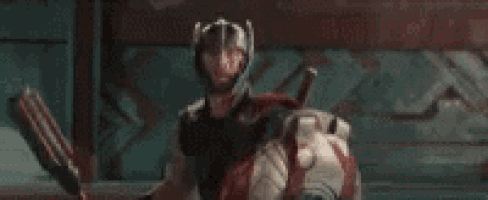 a man in a helmet is laying on a bed with his arm around another man .