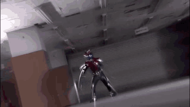 a person in a superhero costume stands in a dark room