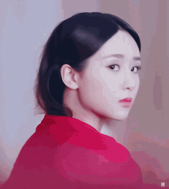 a close up of a woman 's face with a red shirt on