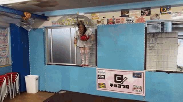a woman stands in a window with a sign that says g on it