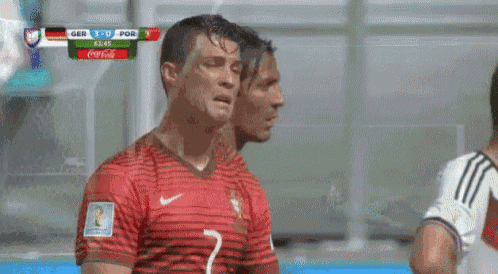 two soccer players are standing next to each other in front of a scoreboard that says coca cola on it .