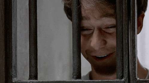 a man behind bars with his eyes closed and his mouth open