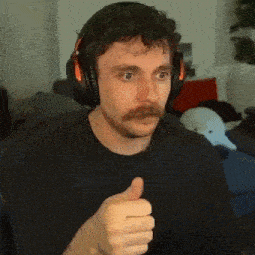 the man is wearing headphones and giving a thumbs up .
