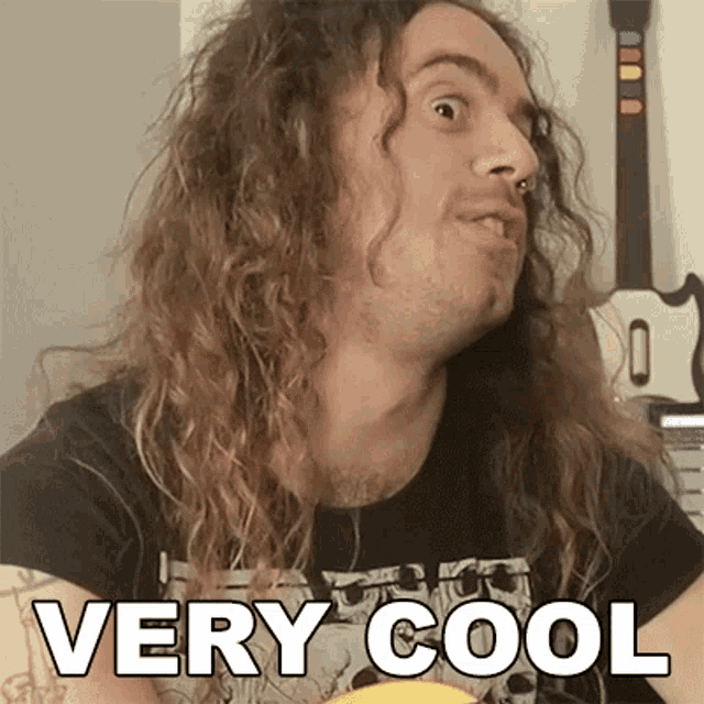 a man with long curly hair is wearing a very cool shirt